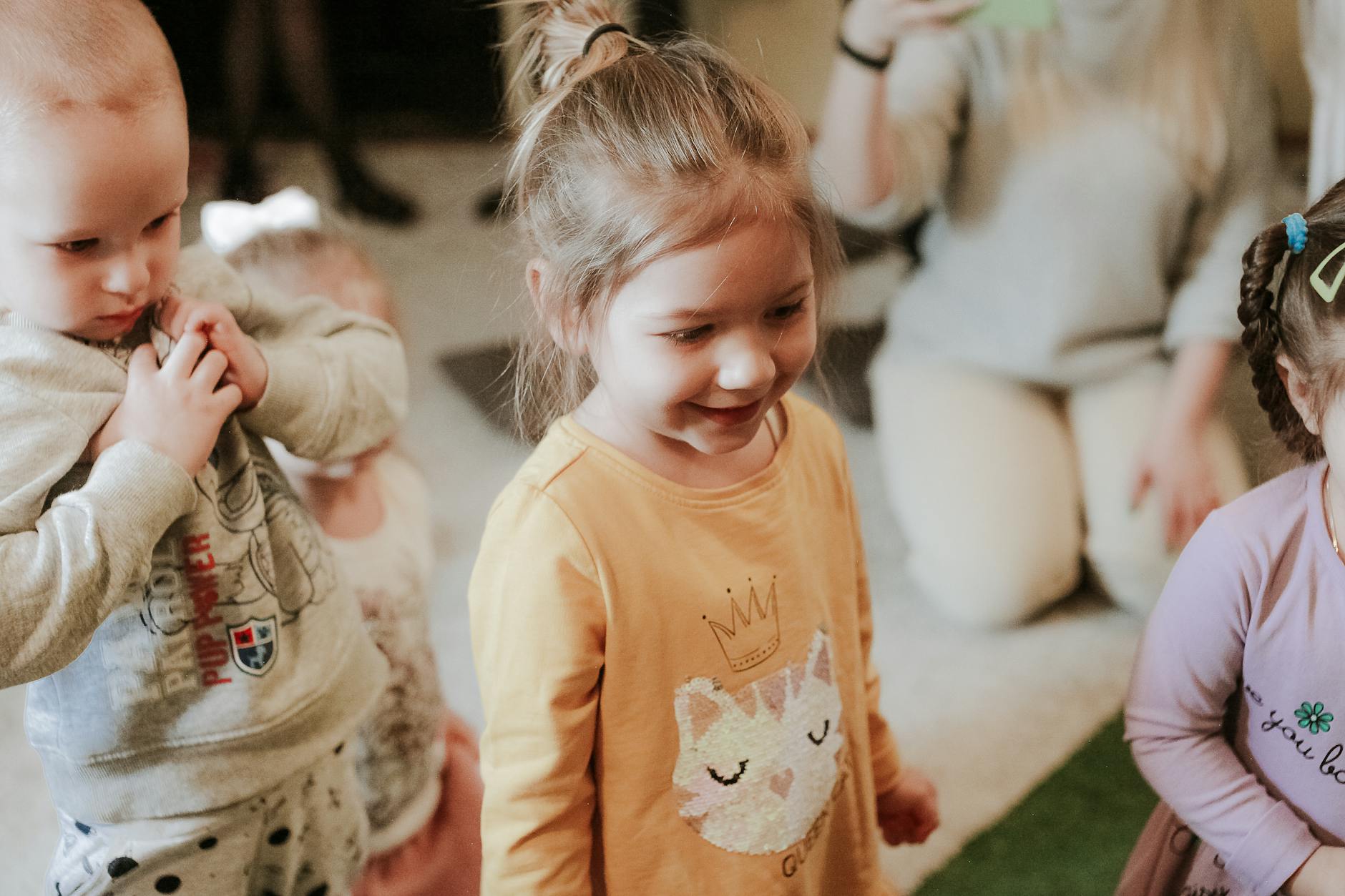 Małe dzieci bawią się zabawkami w pokoju, uśmiechają się do siebie