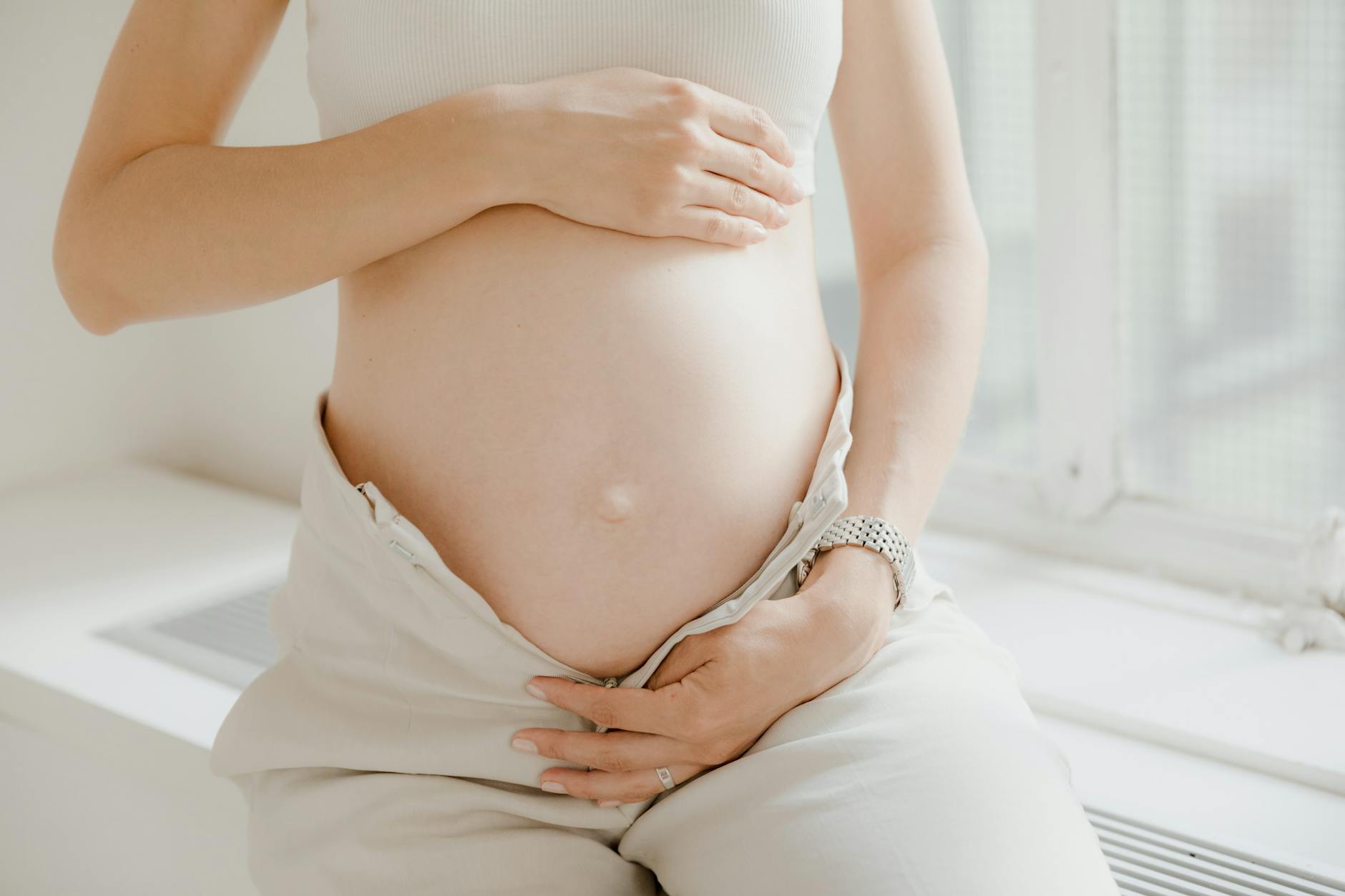 Ciężarna kobieta z czułością obejmująca brzuch z widoczną ciążą