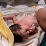Skala Apgar: co oznacza wynik dziecka i kiedy wymaga dalszej diagnostyki? Noworodek ważony przez pielęgniarkę w szpitalu po porodzie
