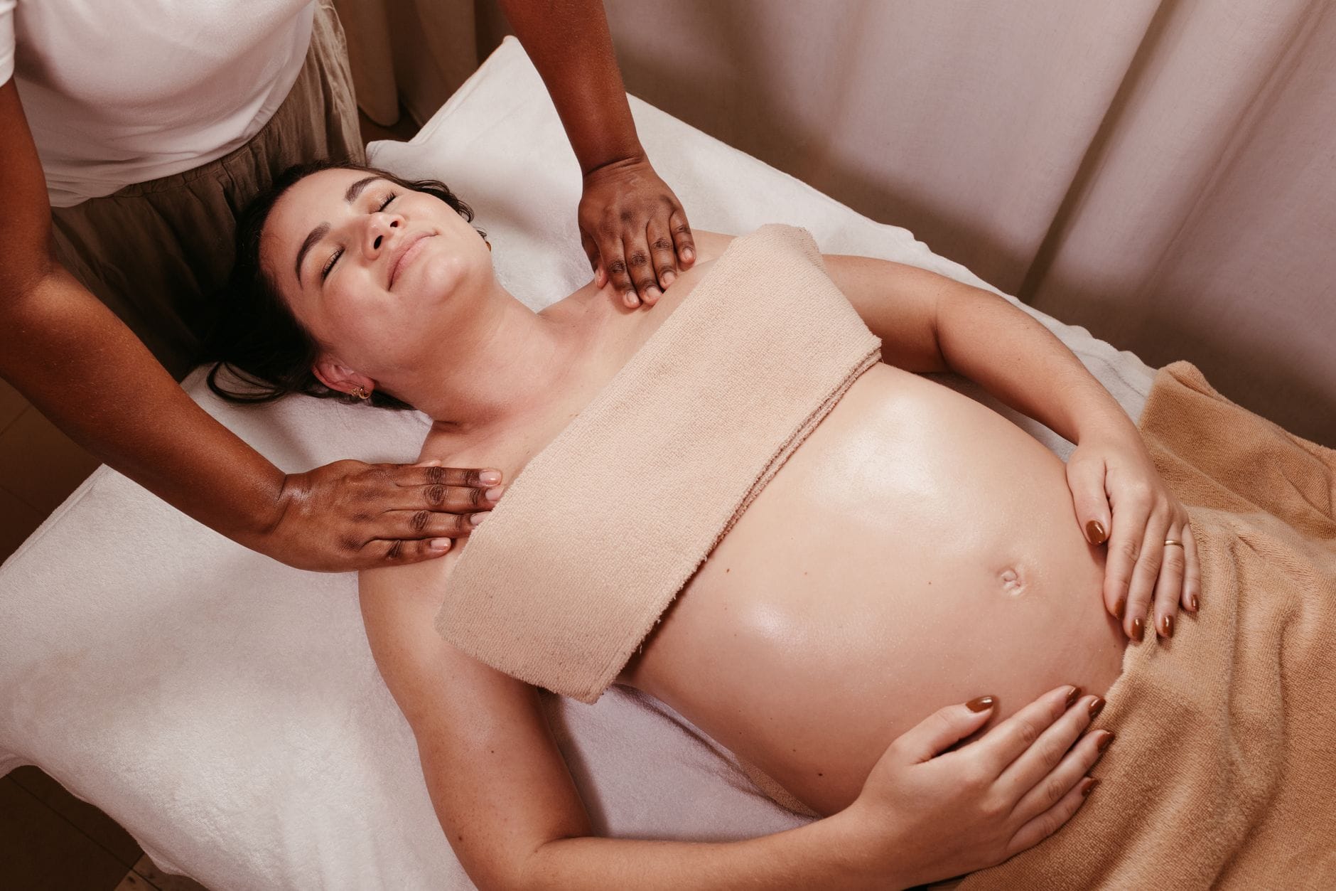 Kobieta w ciąży relaksuje się podczas masażu prenatalnego w spa